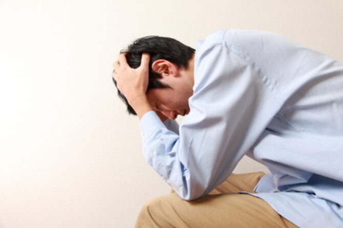 頭を抱える男性 頭を抱える男性